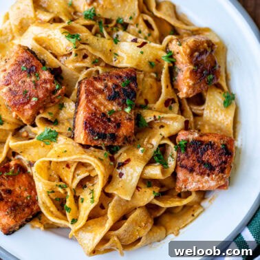 Cajun Pasta With Salmon plated with fresh herbs.