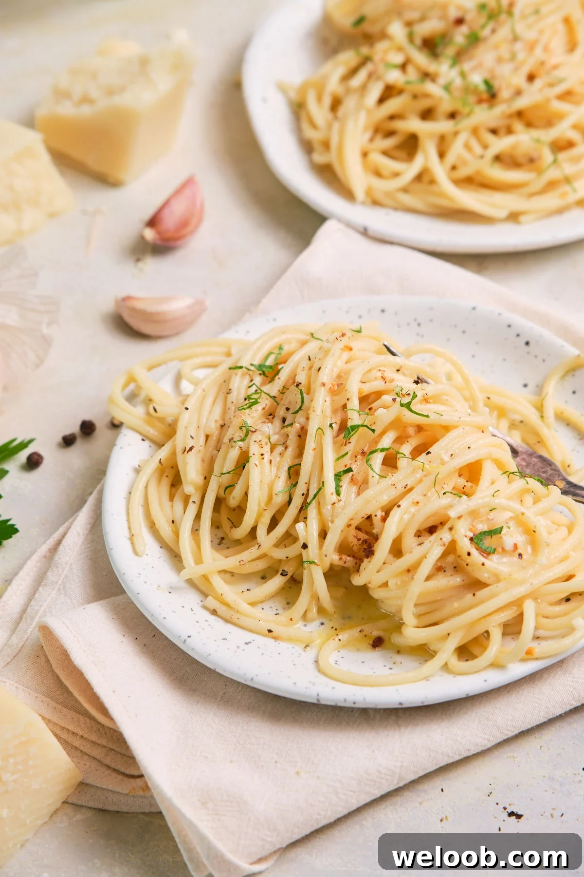 Close-up of a plate of spaghetti cooked with garlic and butter.