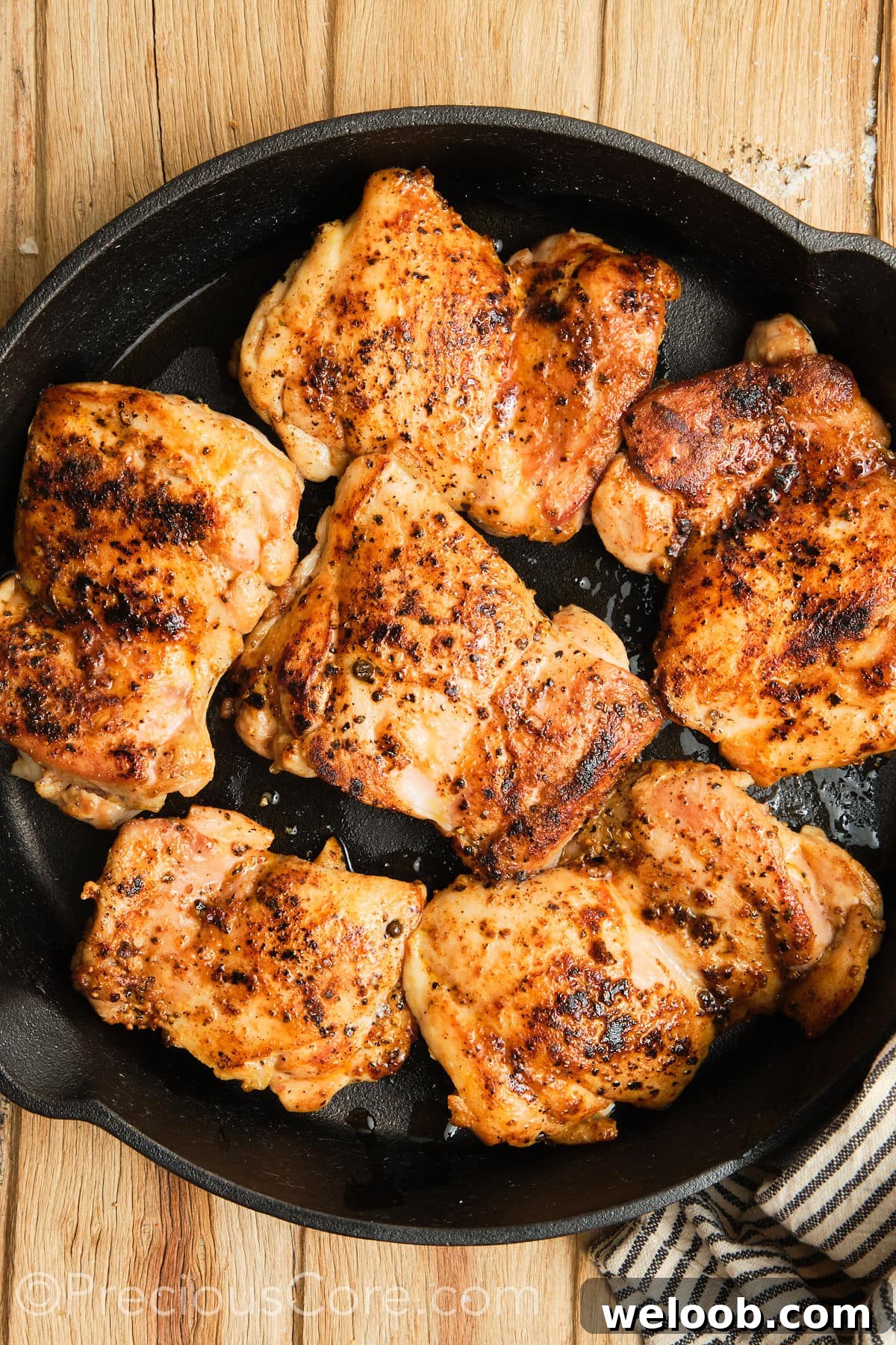 Seared boneless chicken thighs in a skillet.