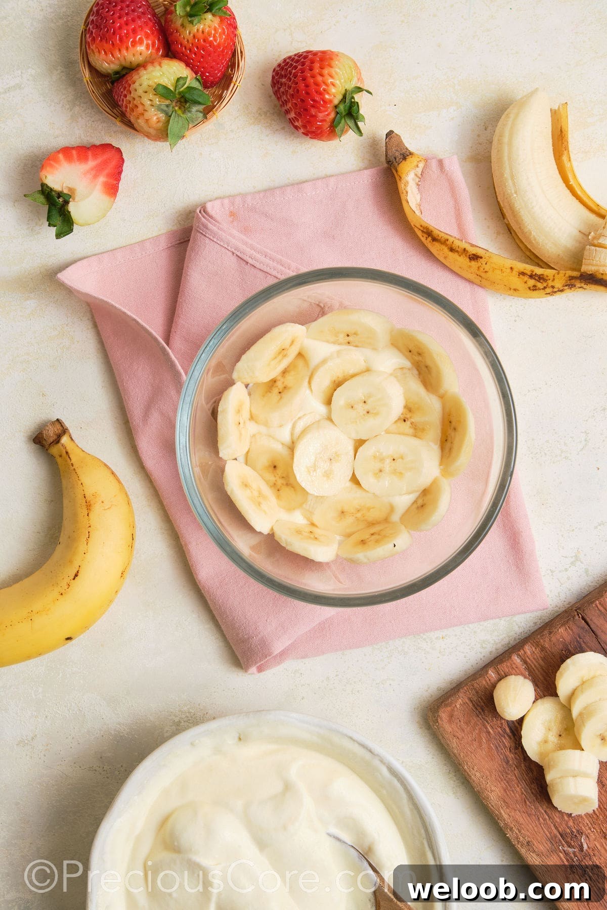 Adding a layer of bananas to pudding.