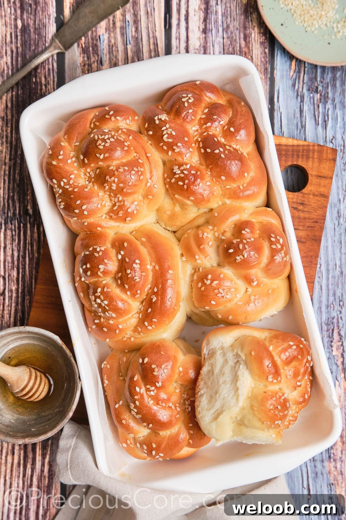 One challah roll pulled away to show texture.