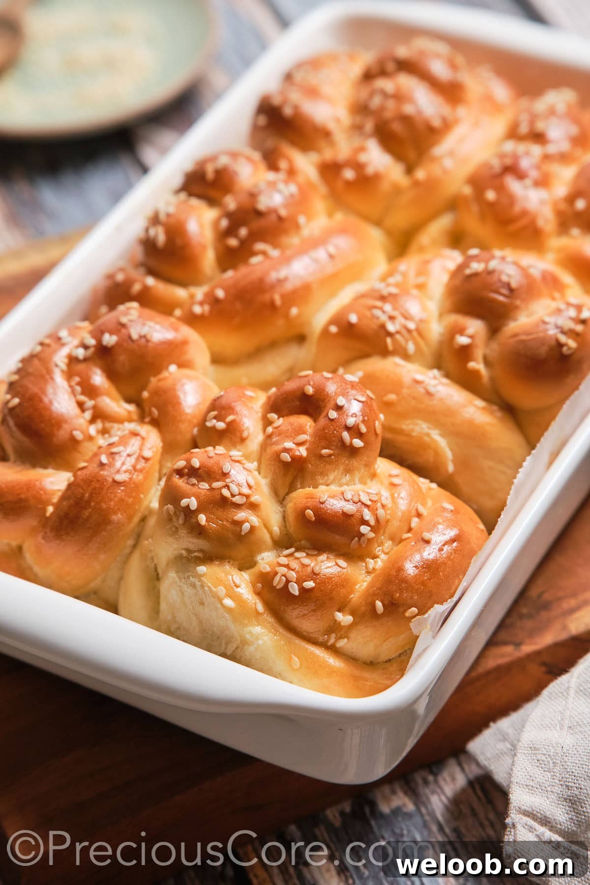 A baking dish with baked homemade challah rolls.