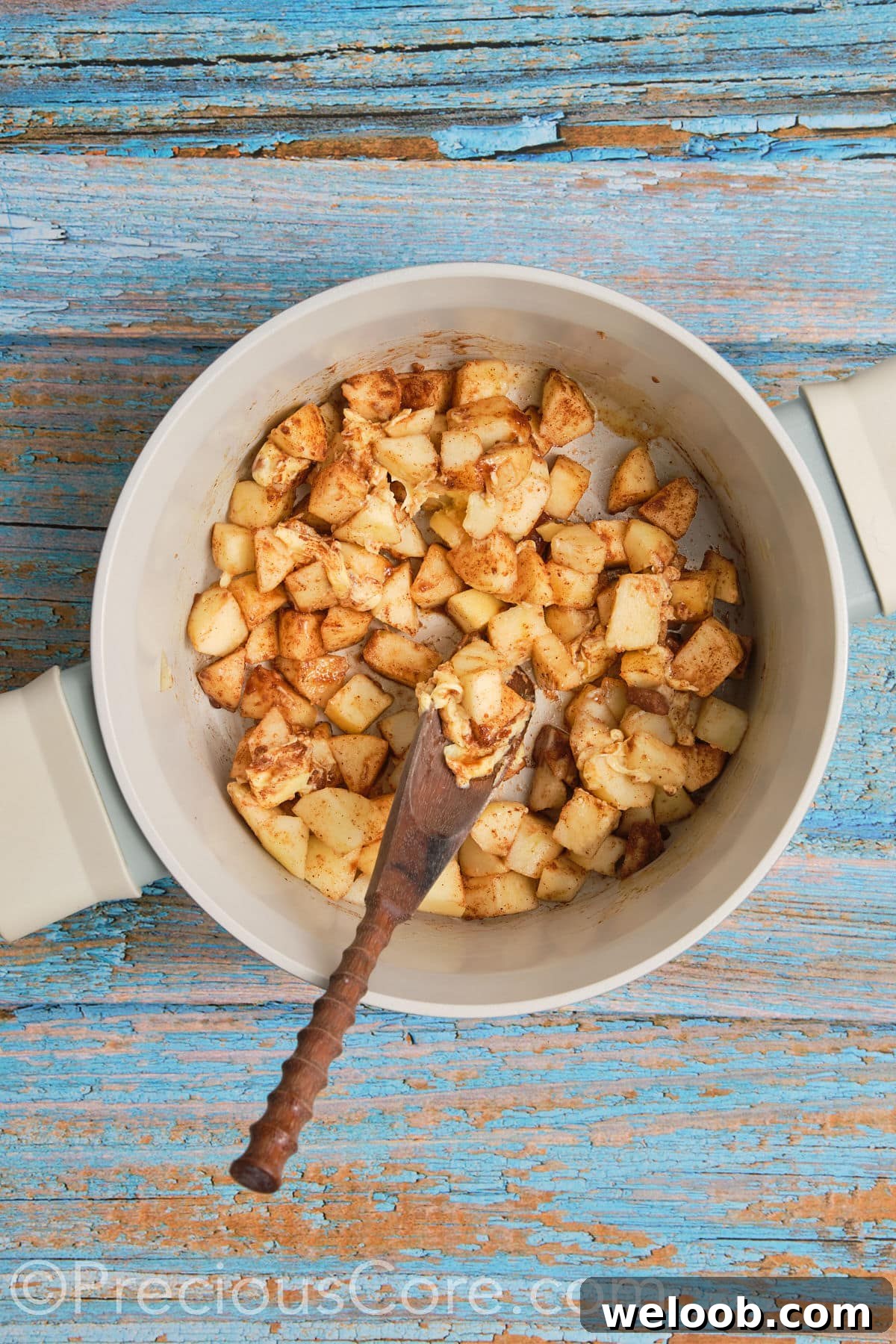 Apple pie filling for cinnamon rolls cooking in a pot.