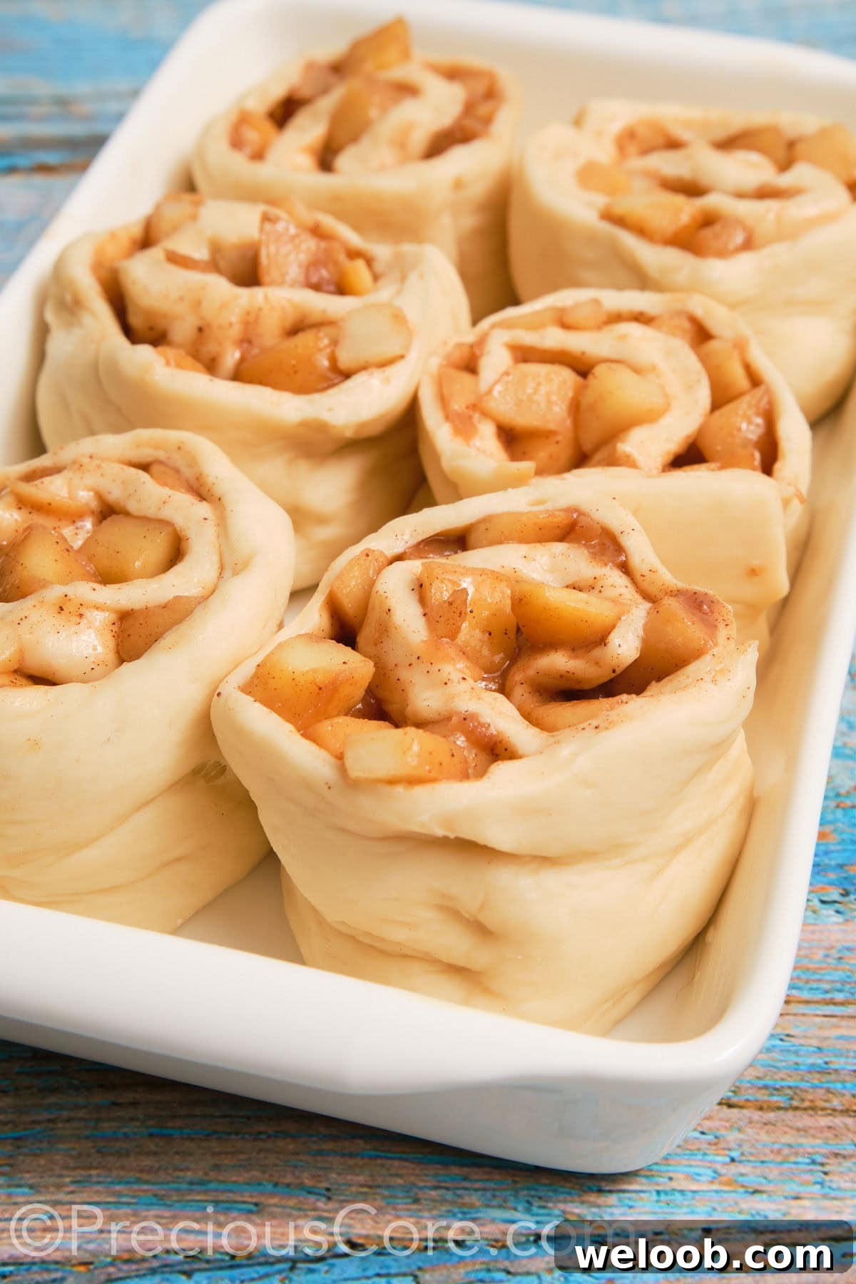 Close up of dough filled with apple pie filling.