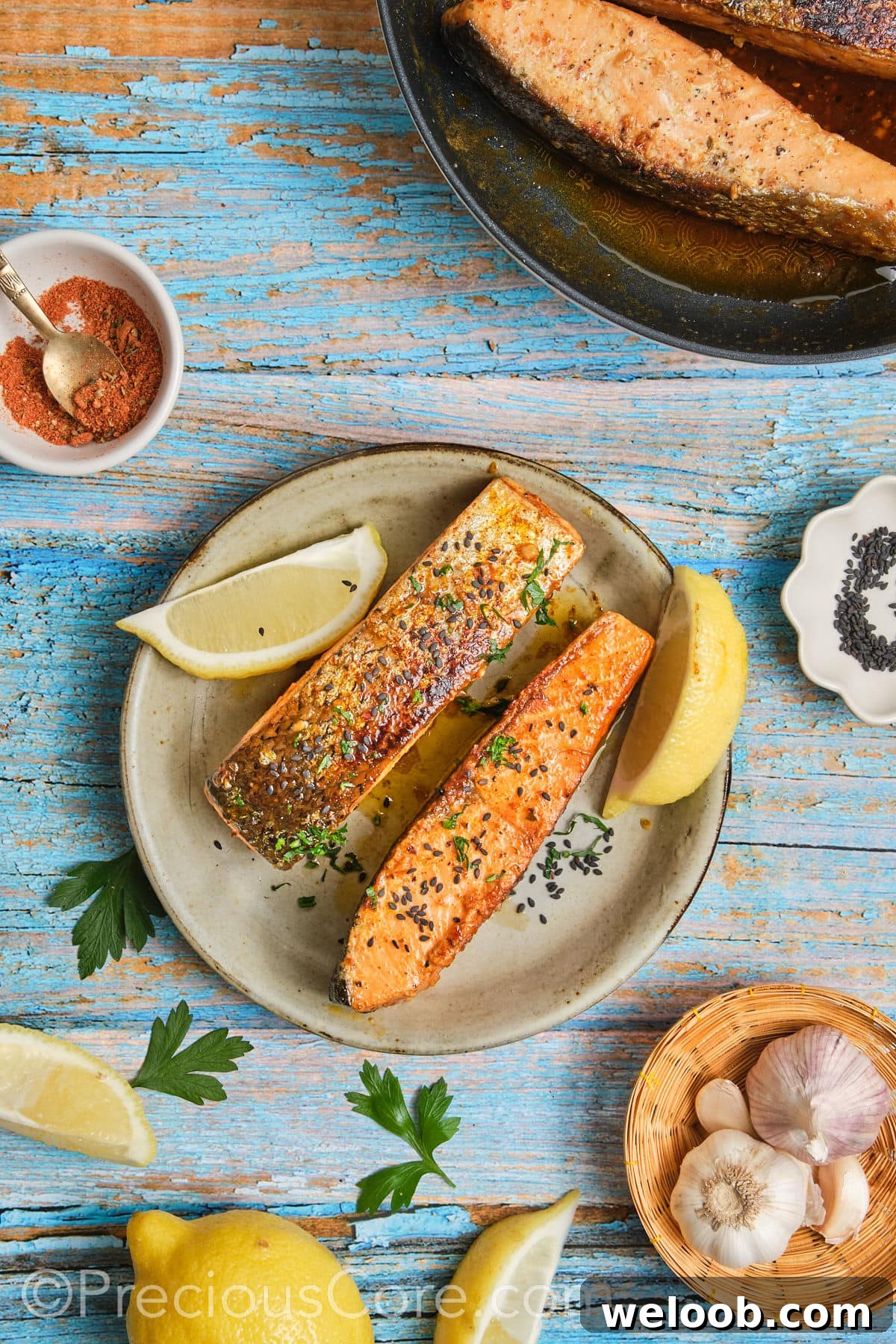 Garnished salmon with chopped parsley and lemon wedges.