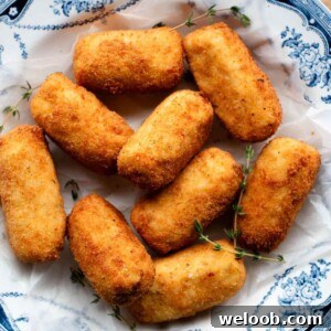 A close up cropped image of chicken croquettes in a blue and white bowl.