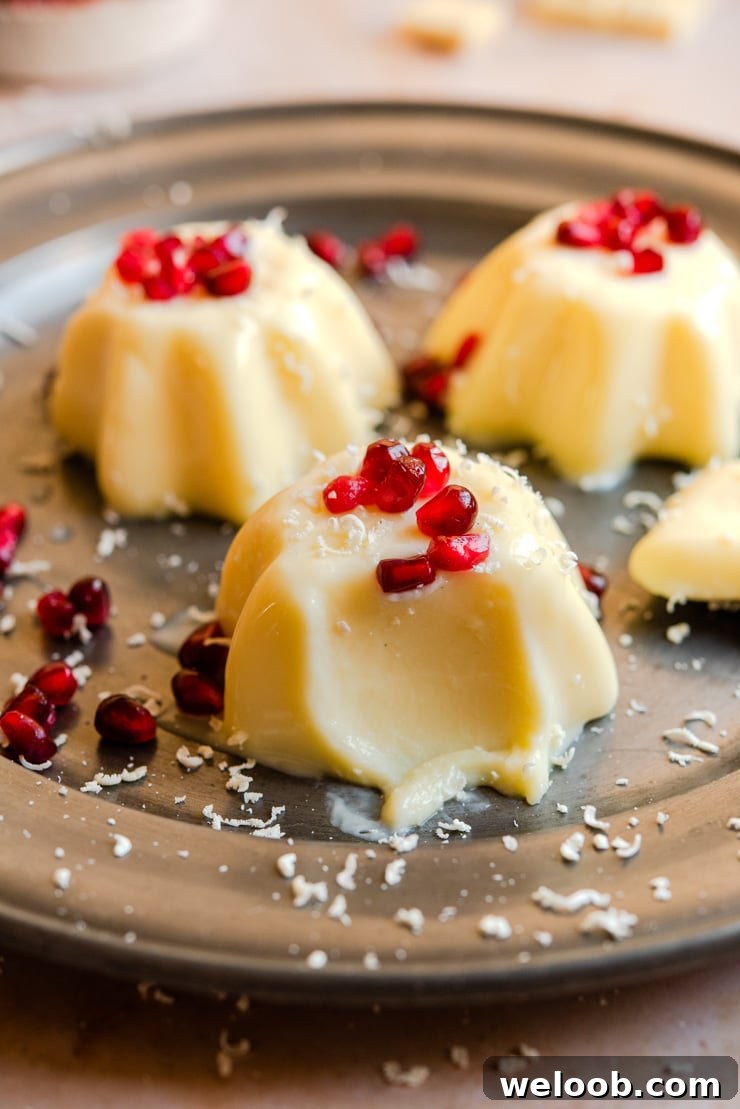 A close up of white chocolate panna cotta with a bite out on a plate