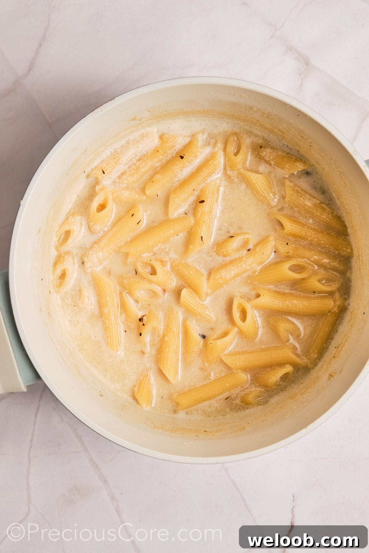 Pasta added to creamy liquid.