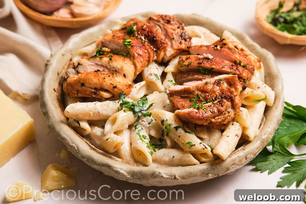 Creamy pasta topped with sliced boneless chicken thighs.