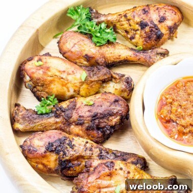 Grilled chicken drumsticks in a wooden serving dish.