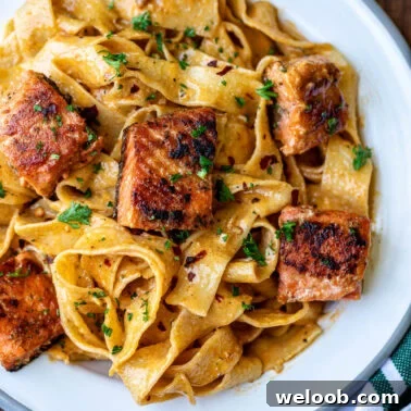 Cajun Pasta With Salmon plated with fresh herbs.