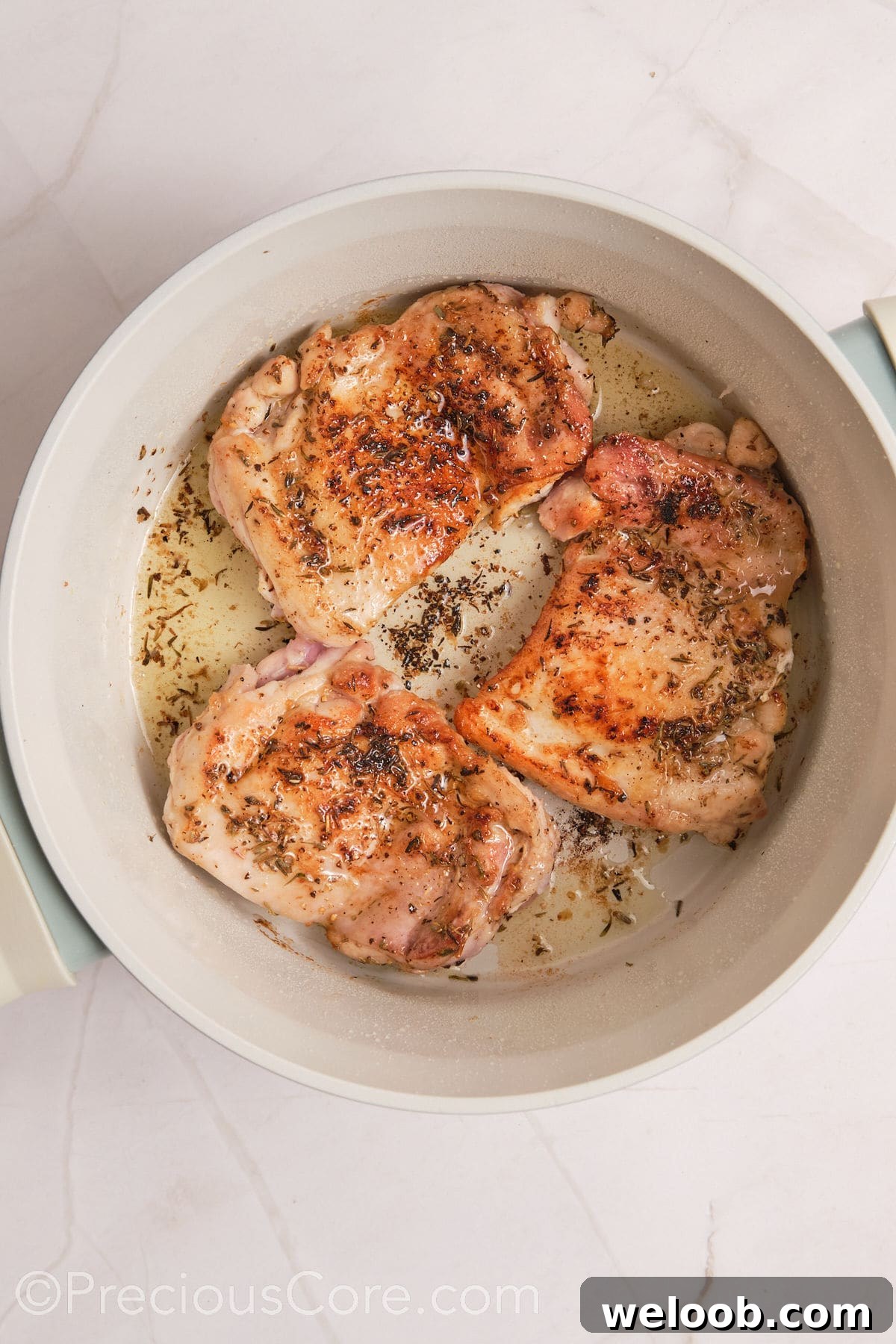 Browned chicken thighs in a pot.