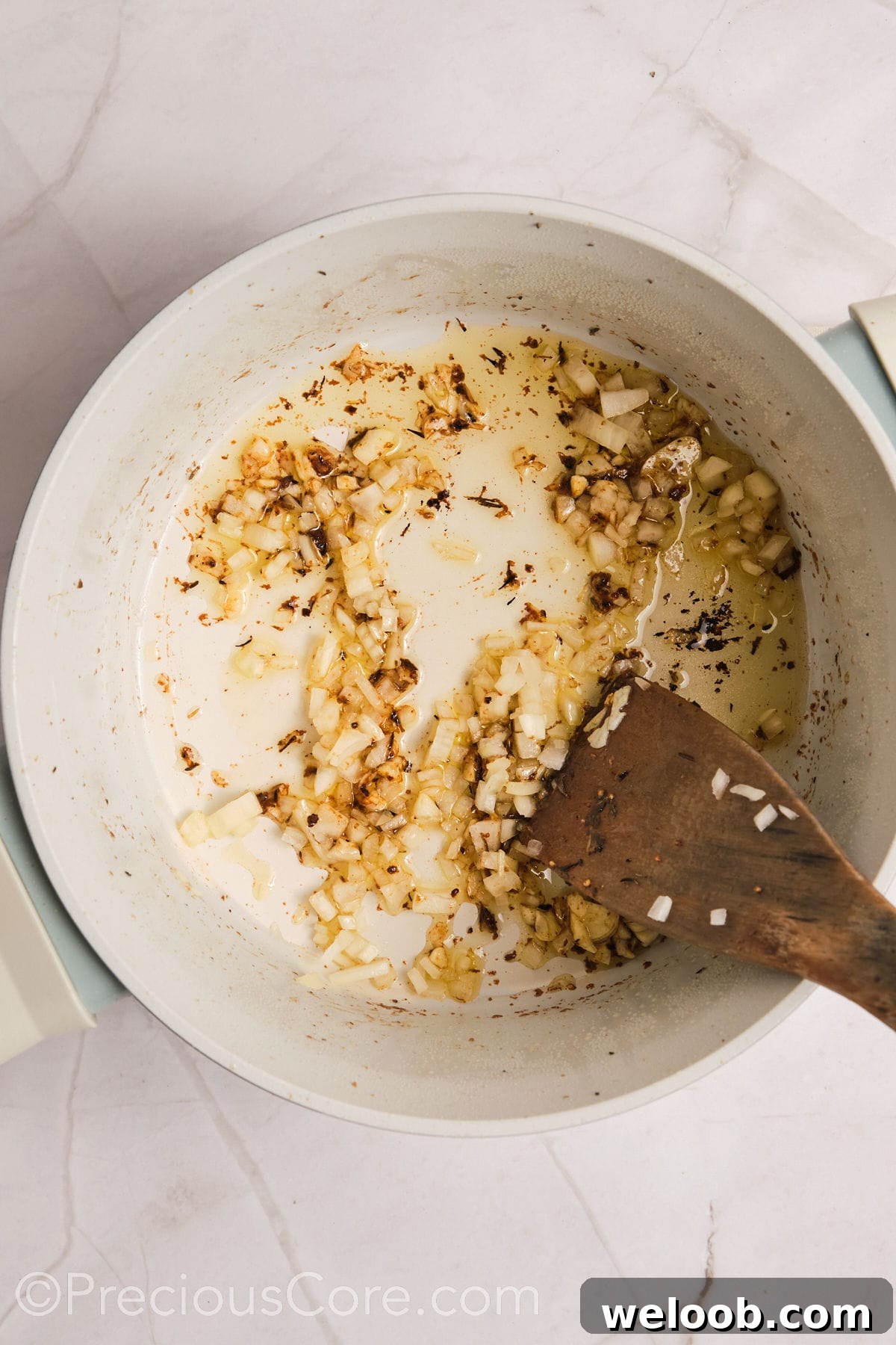 Sautéing onions and garlic in a pot.