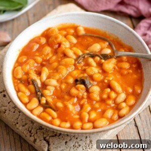 A bowl of tomato beans in a bowl with sage leaves
