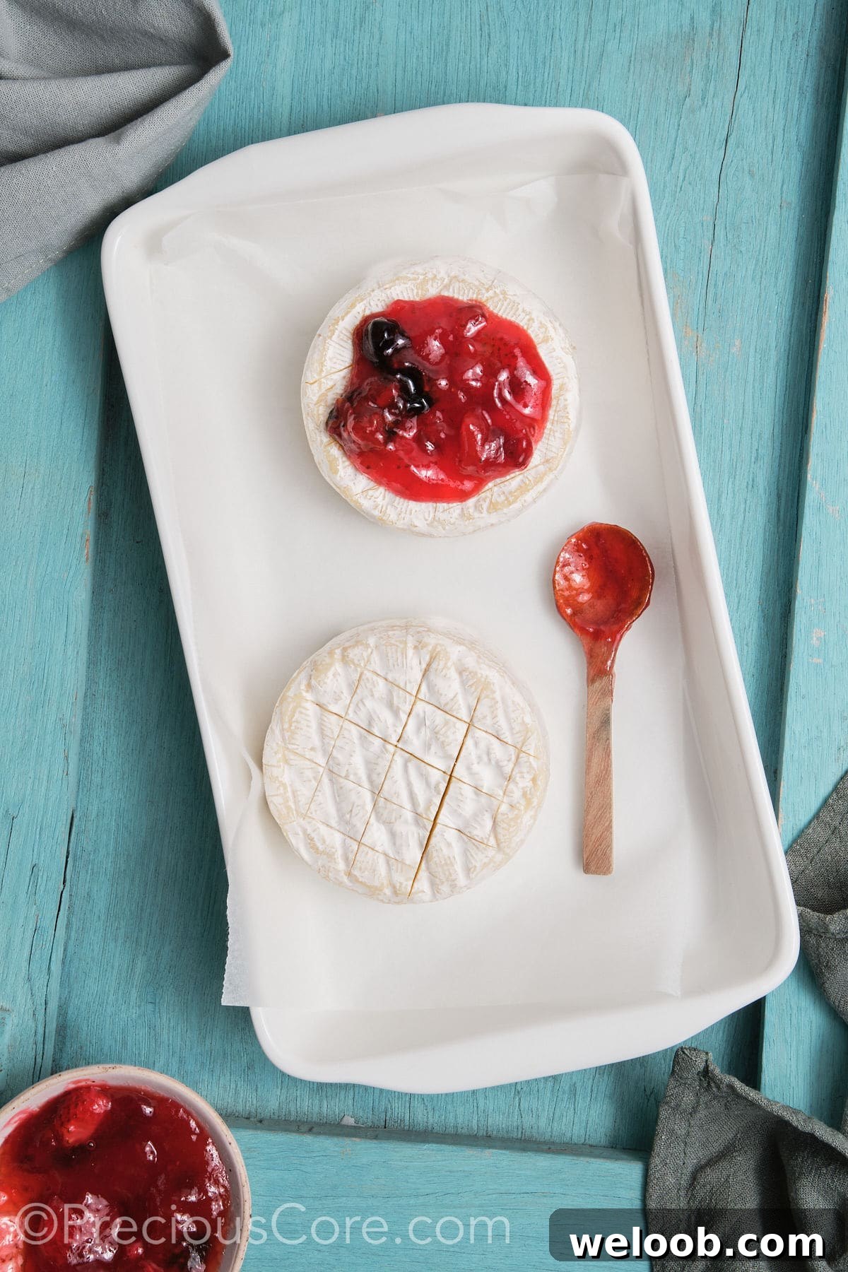 Brie transferred to a baking dish and topped with preserves.