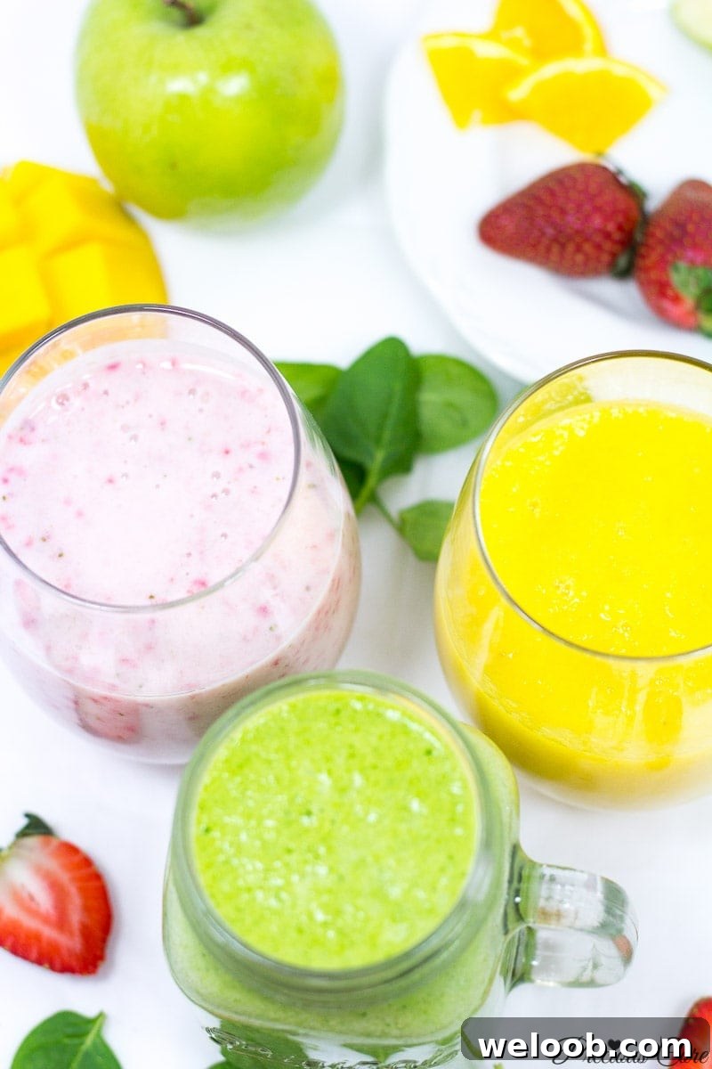 Three differently-colored smoothies in small glasses.