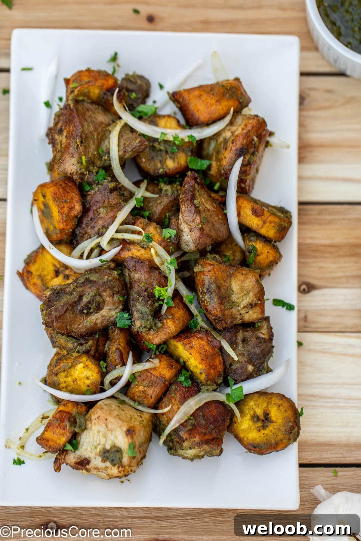 Fried pork an plantains topped with sliced onions.