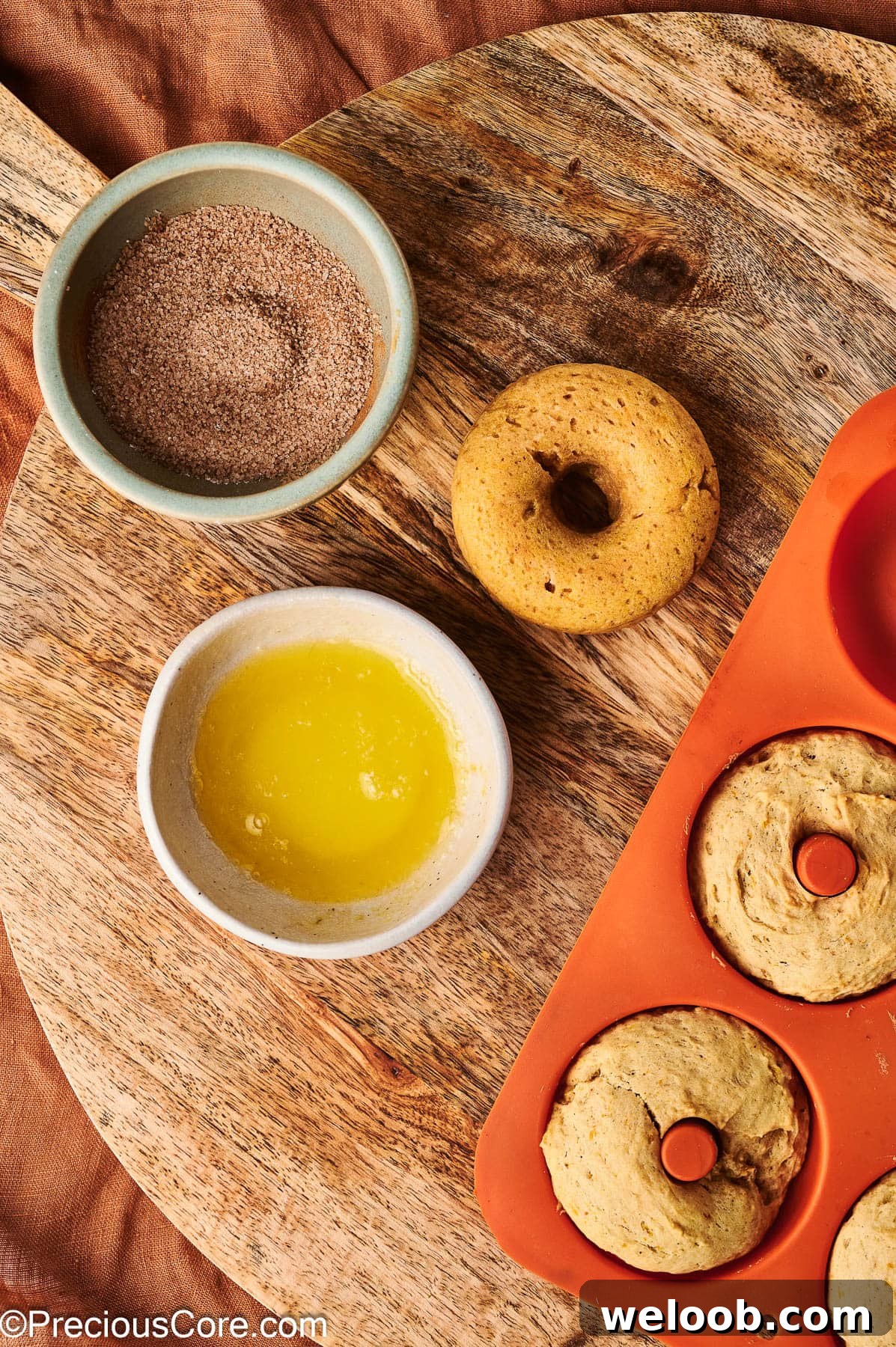Preparing to coat doughnuts with cinnamon sugar.