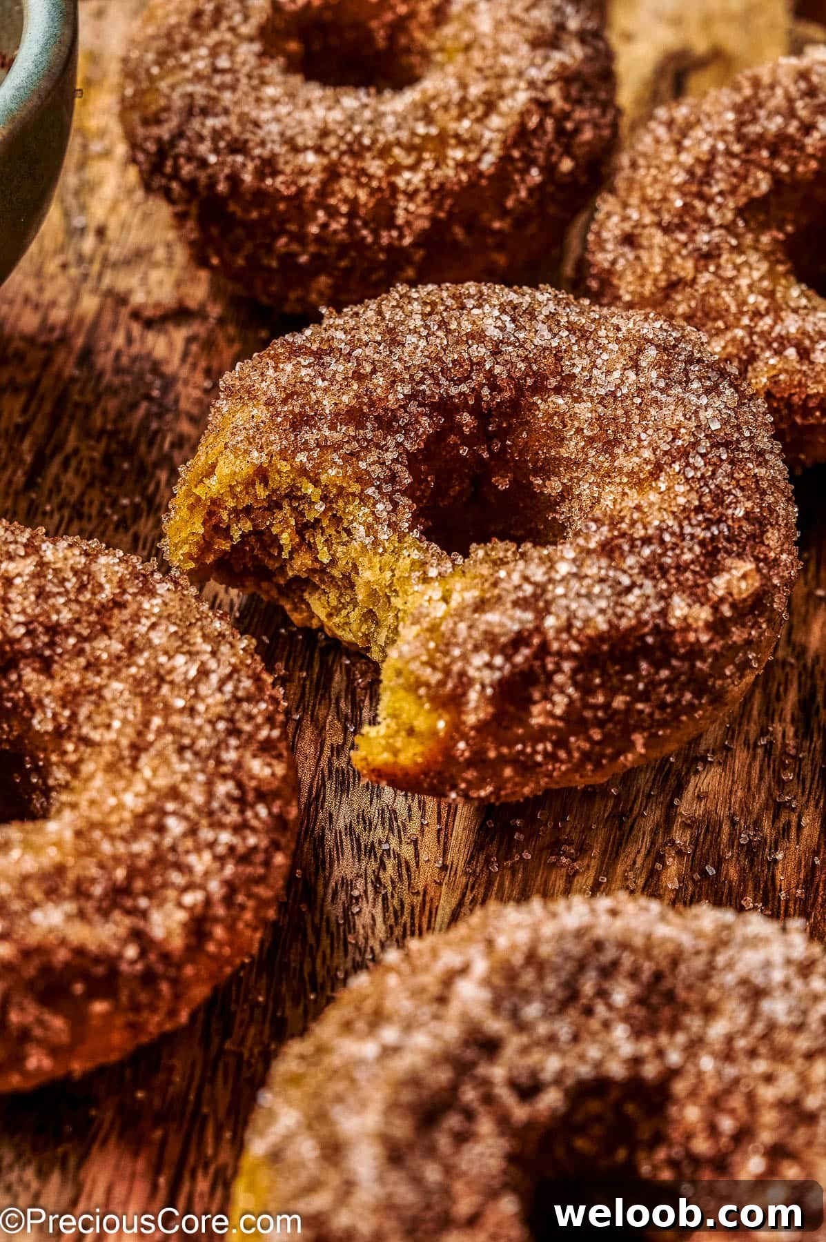 Baked pumpkin doughnuts on a wooden board.