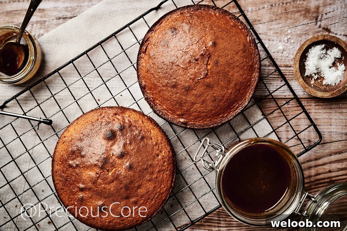 Two 8-inch cakes, cooling on a cooling rack.