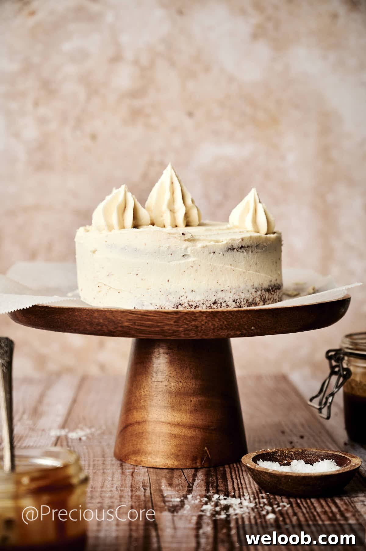 Salted caramel cake with more caramel frosting piped on top.