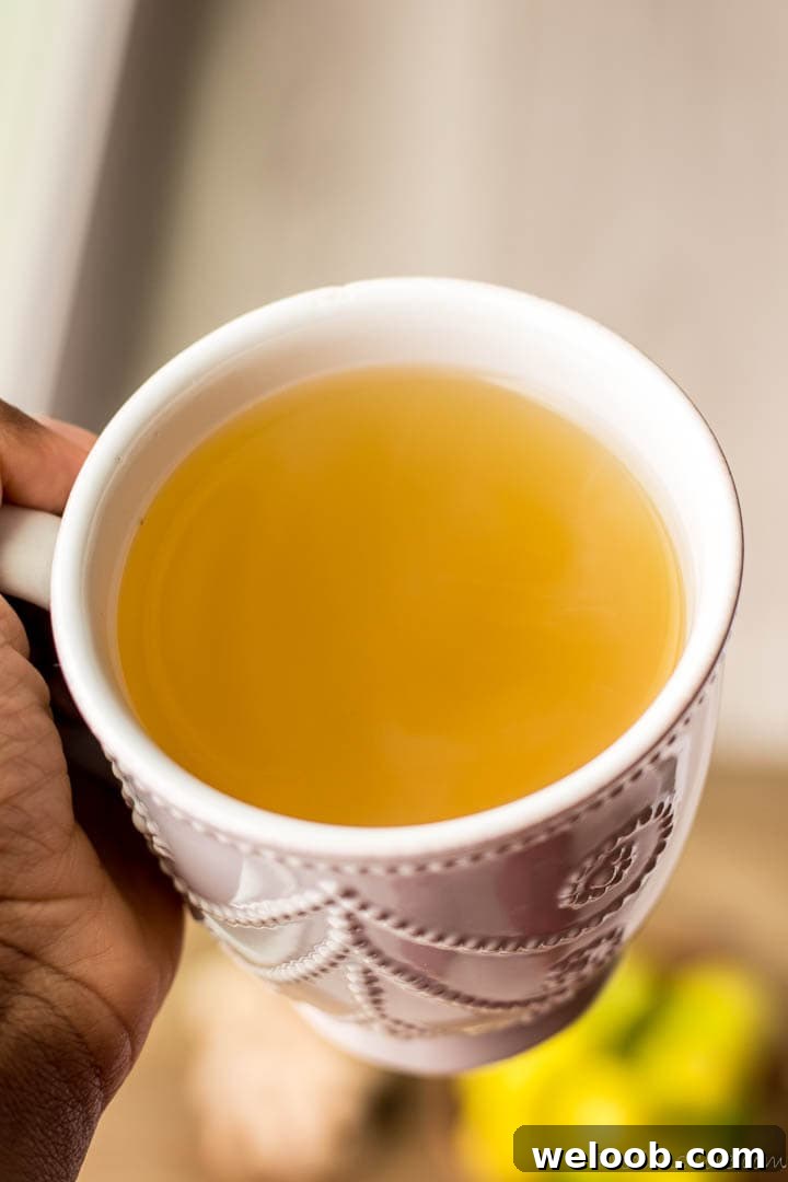 Hand holding a mug of ginger tea