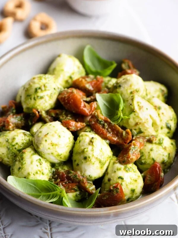 Mozzarella bocconcini in a bowl with basil pesto and tomatoes