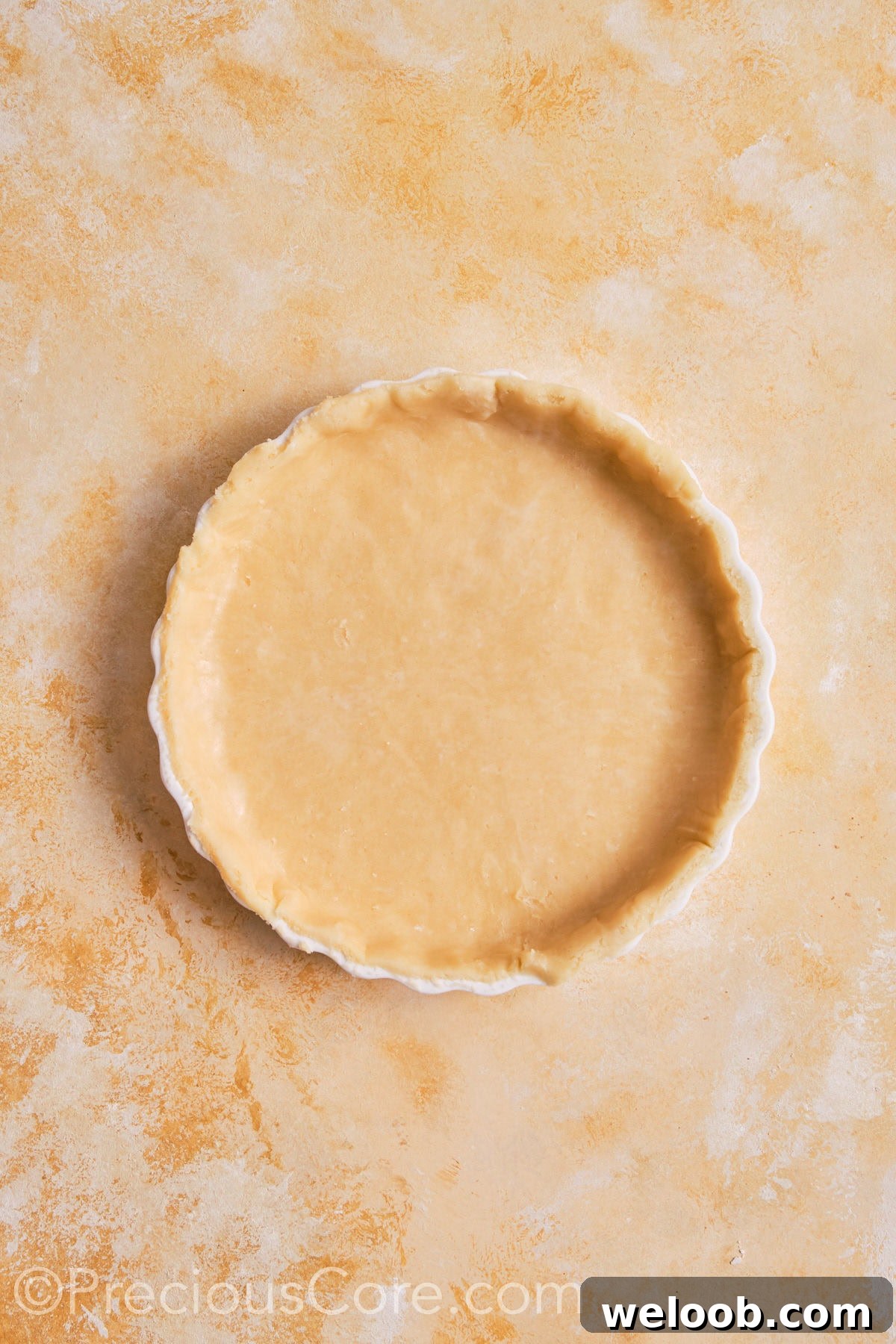 Pumpkin pie dough fitted into pie dish.