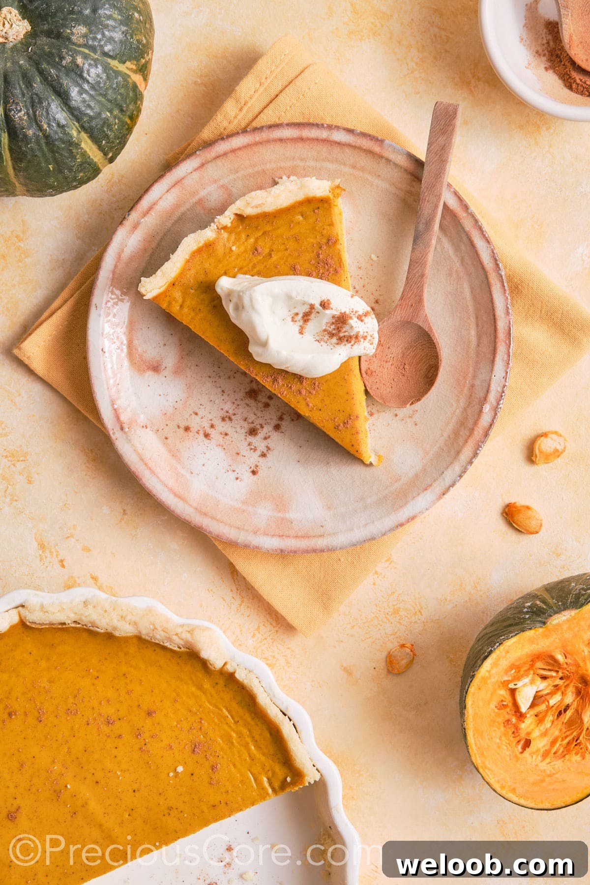 Slice of homemade pumpkin pie served with cream.