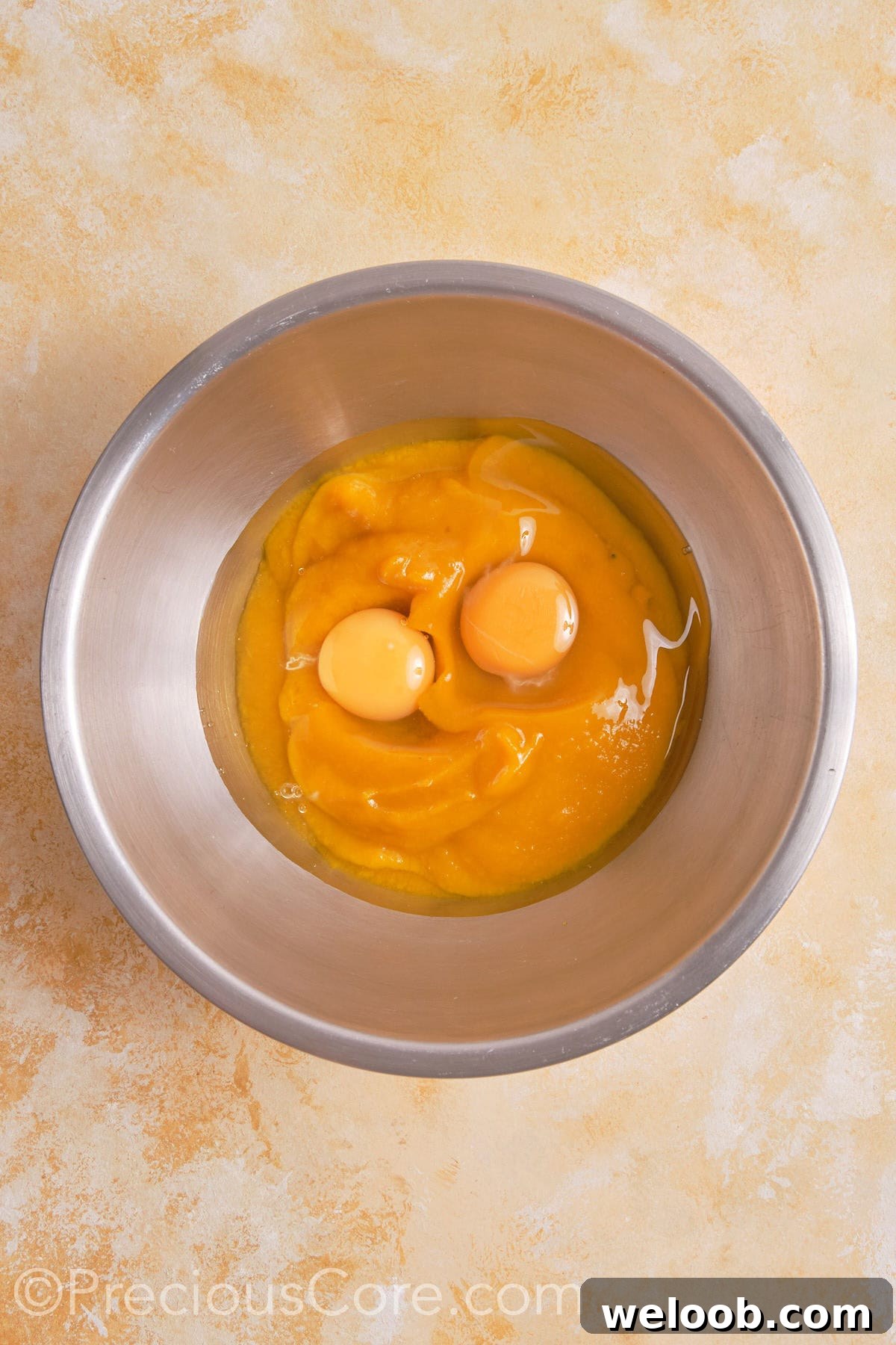 Eggs and pumpkin puree in a bowl.