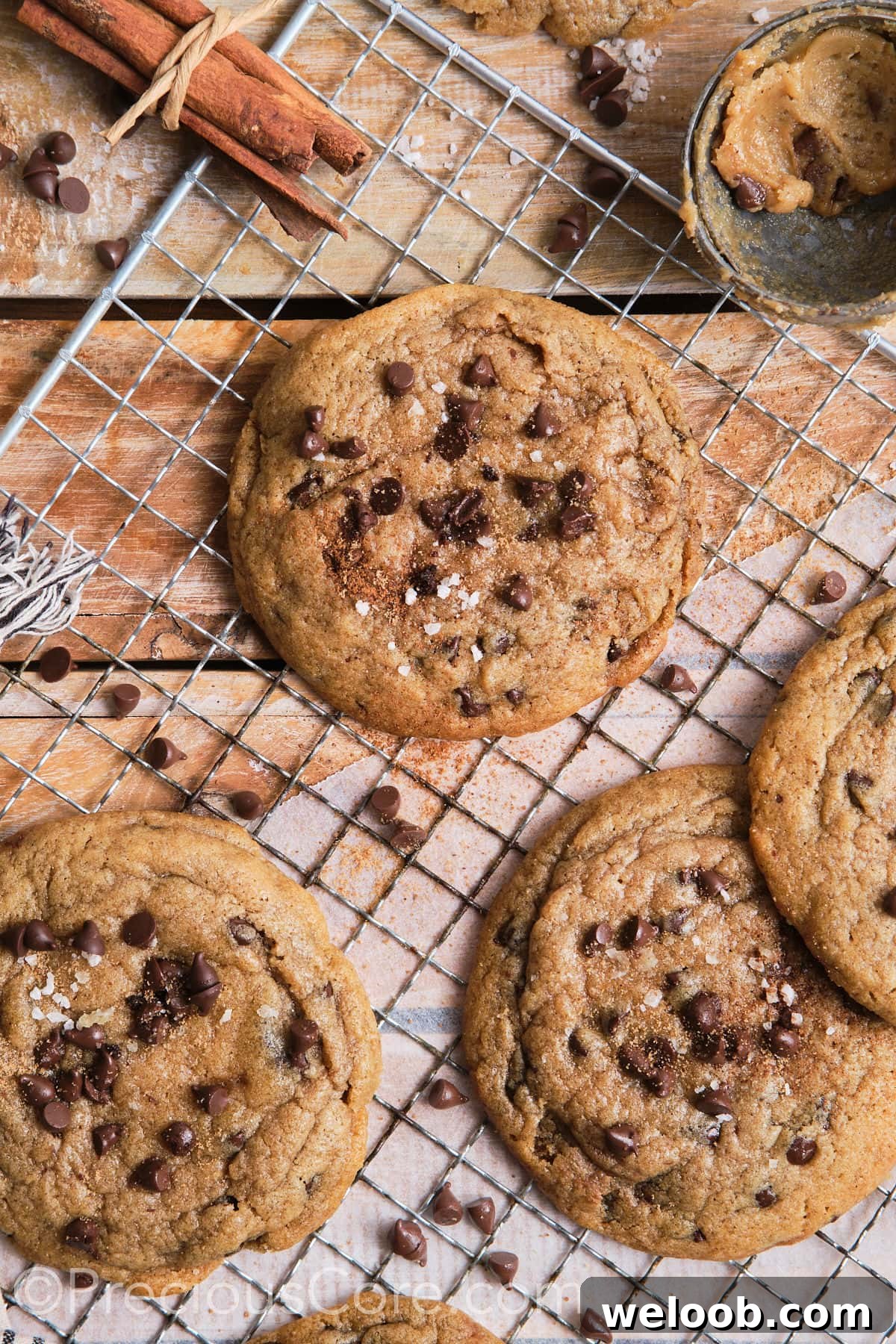 Cinnamon chocolate chip cookies on a wire rack, sprinkled with sea salt