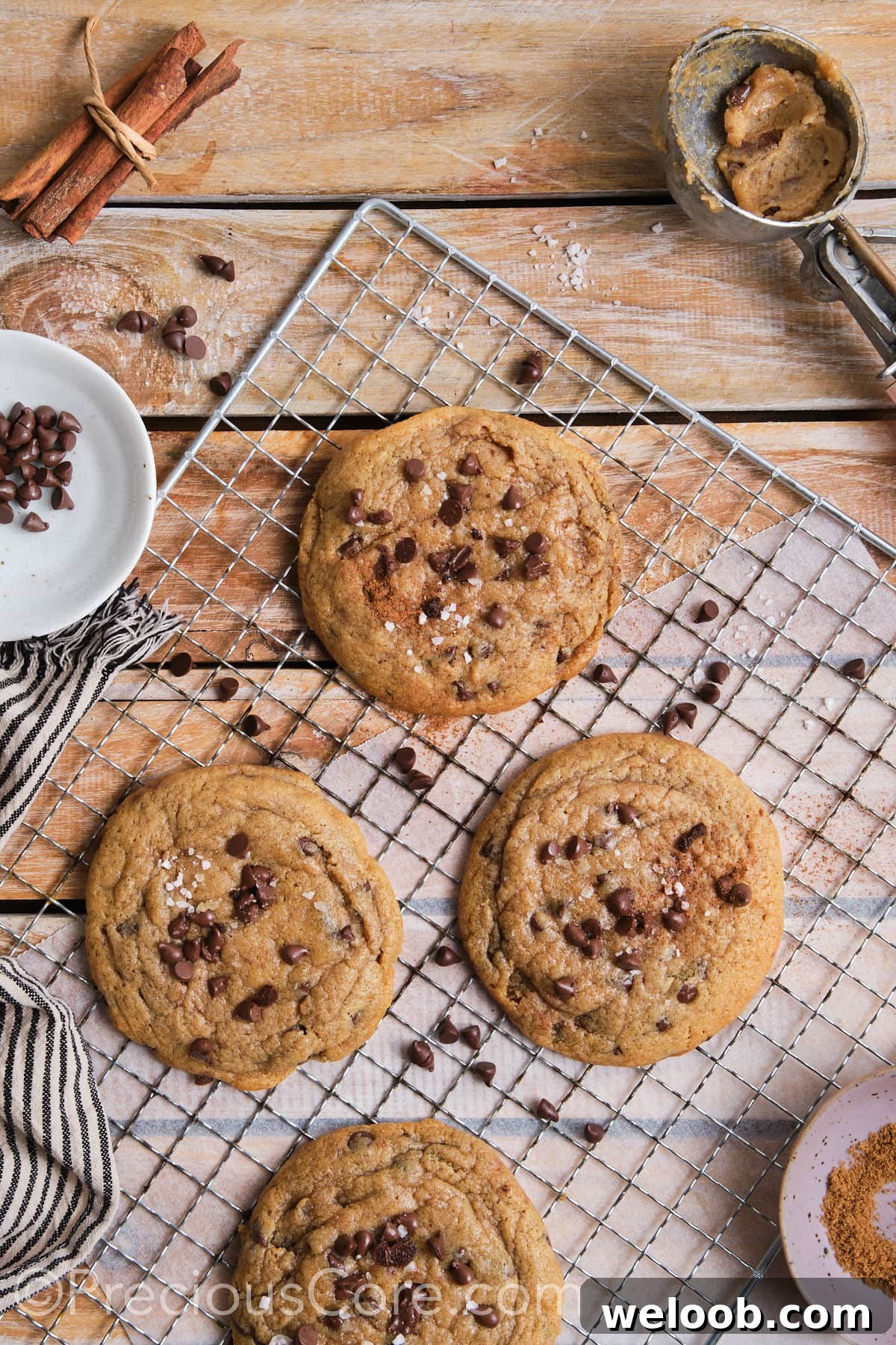 wire rack with cinnamon and chocolate chip cookies topped with flaky sea salt. 