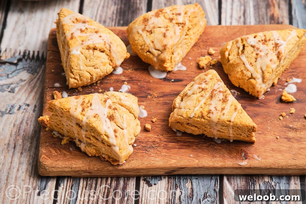 Buttery Sweet Potato Scones with Maple Glaze Recipe 18 Homemade scones on a chopping board.