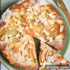 Italian pear almond cake on a plate with a slice cut out.