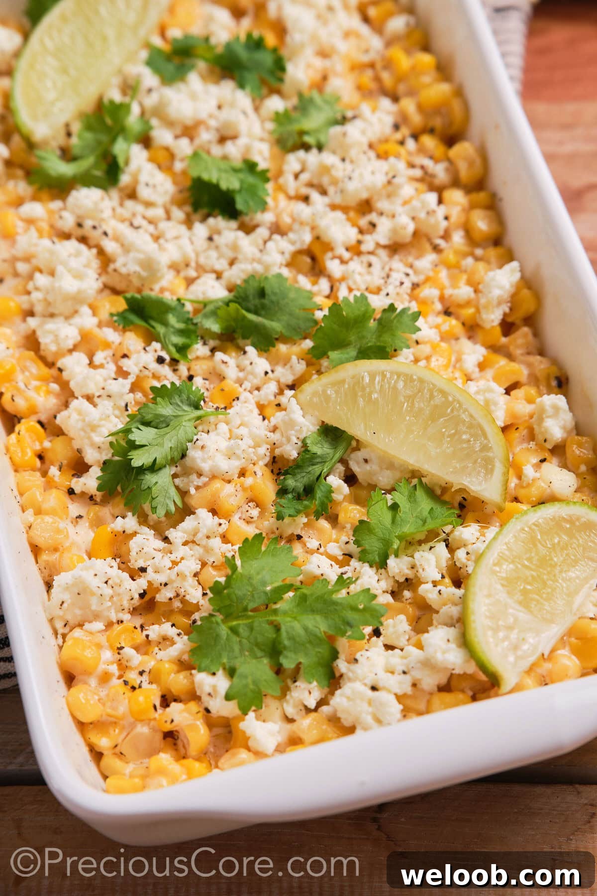 Close up of corn casserole topped with lime wedges.
