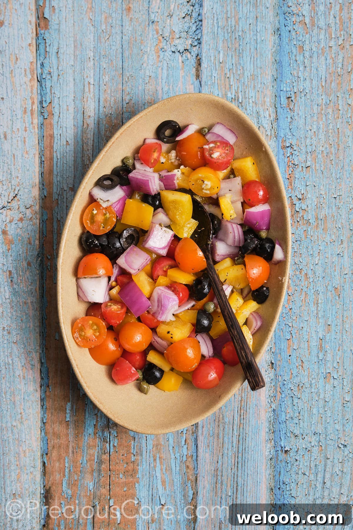 Diced veggies coated in olive oil and seasonings, in a bowl.