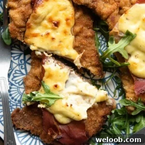 A close up of a veal cutlet cut in half topped with prosciutto and parmesan cream