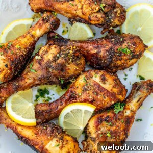 Cooked lemon pepper drumsticks on a white plate.