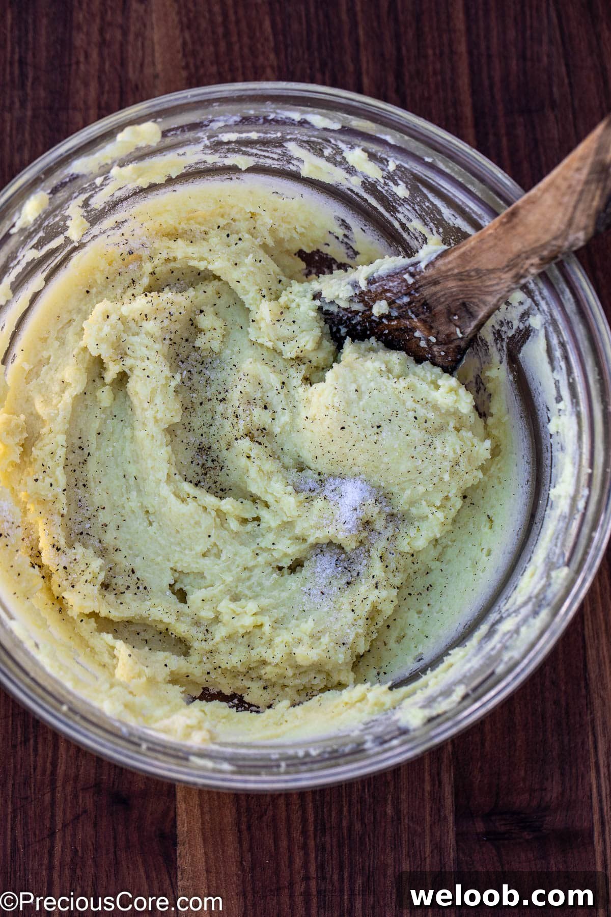 Salt and pepper added to creamy mashed potatoes.