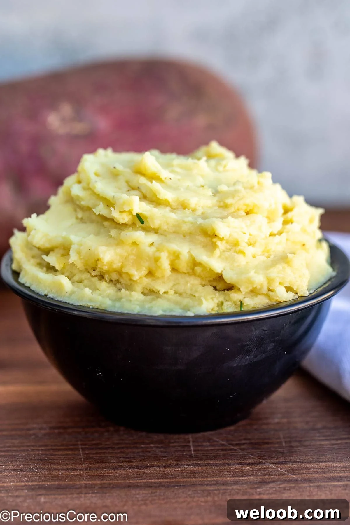 Mashed white sweet potatoes in a black bowl.