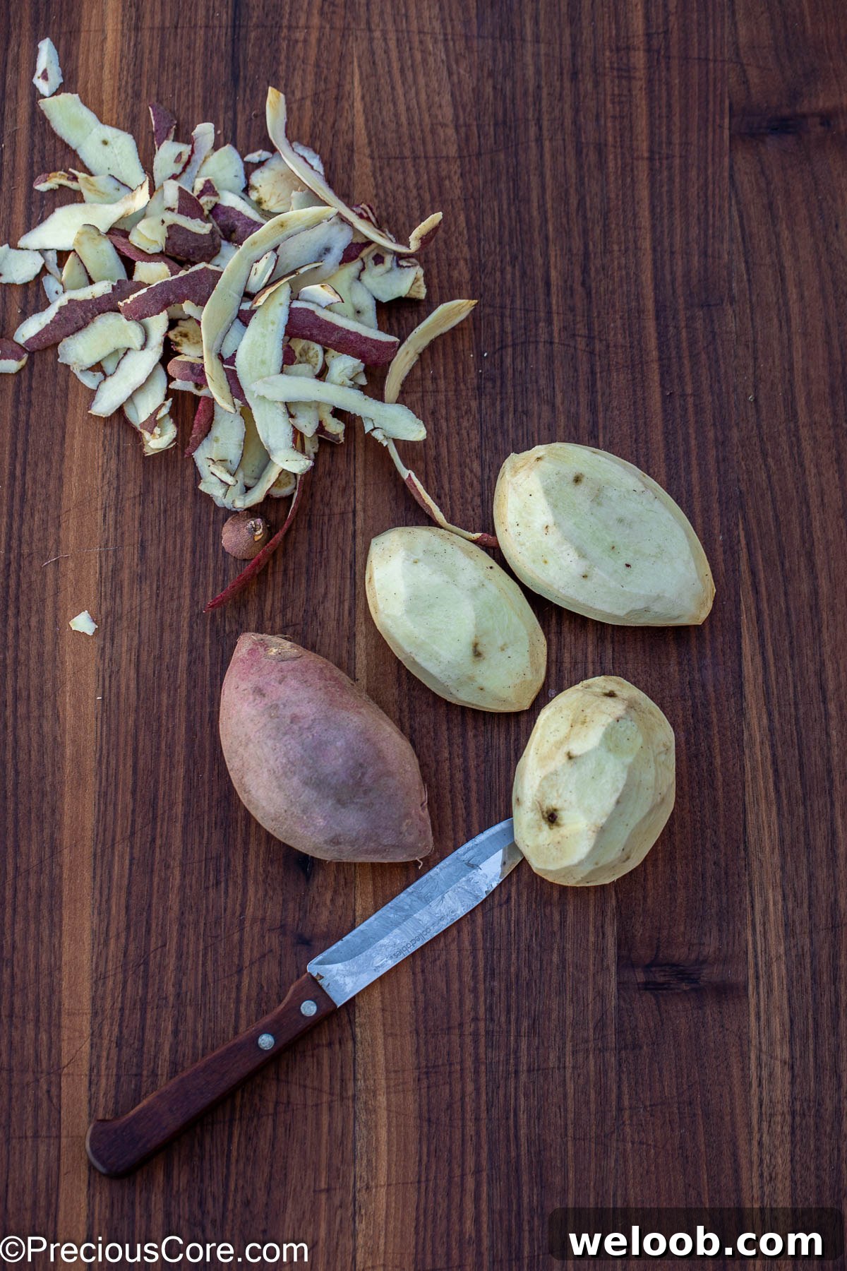 Peeling white sweet potatoes on a cutting board.