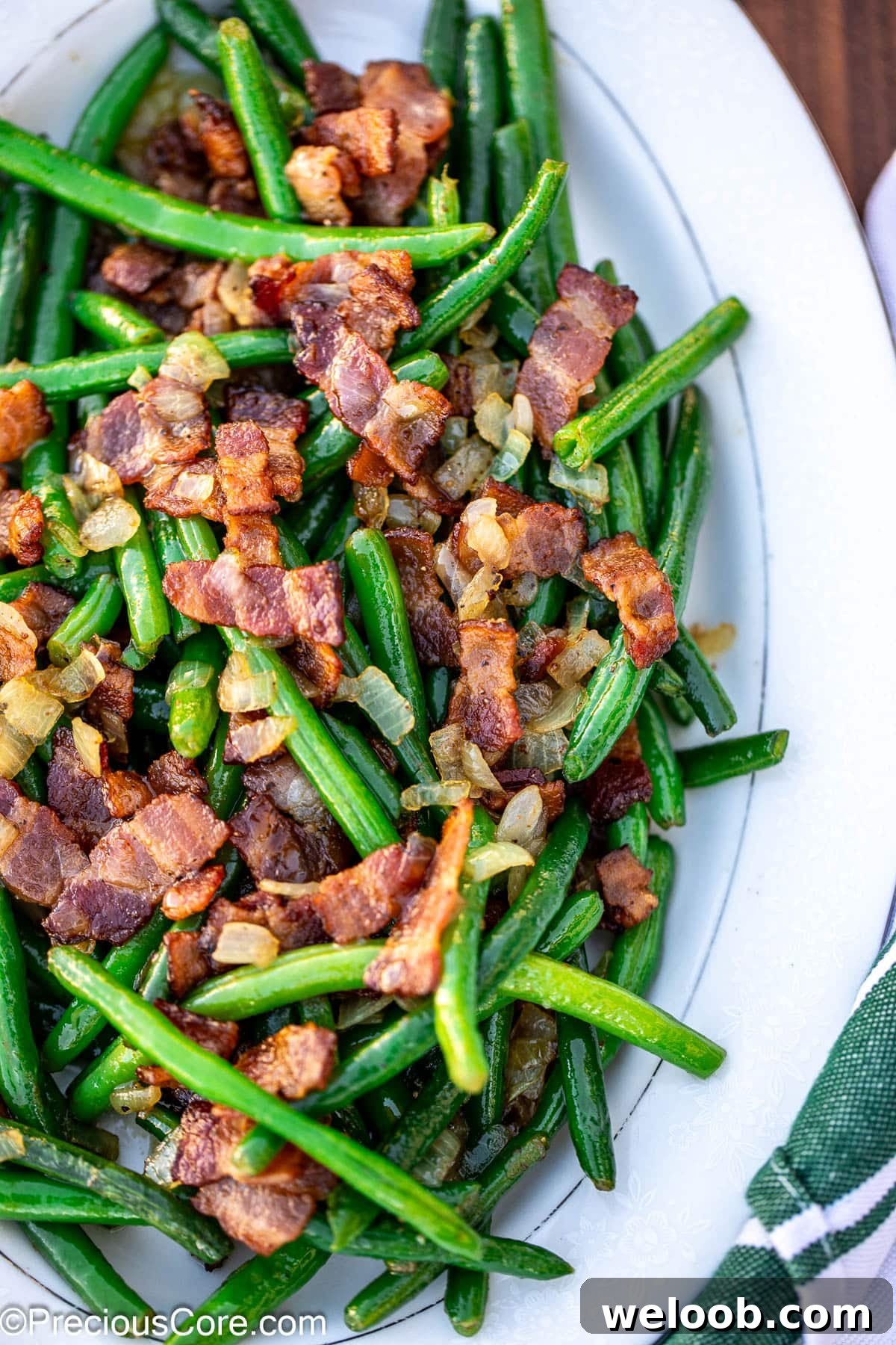 Bright colored green beans and bacon on tray.