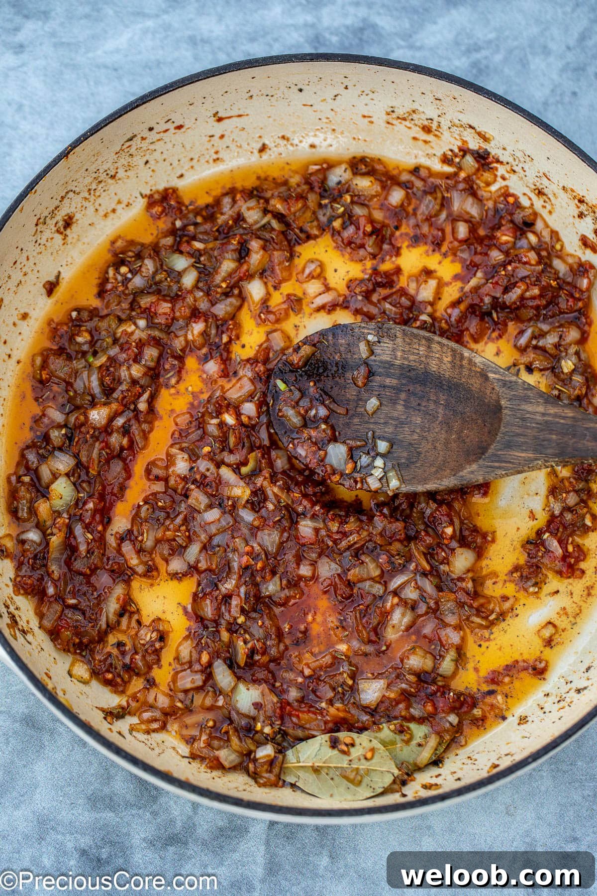adding tomato paste to the pan.