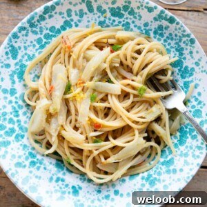 A cropped square image of roasted fennel pasta in a blue bowl.