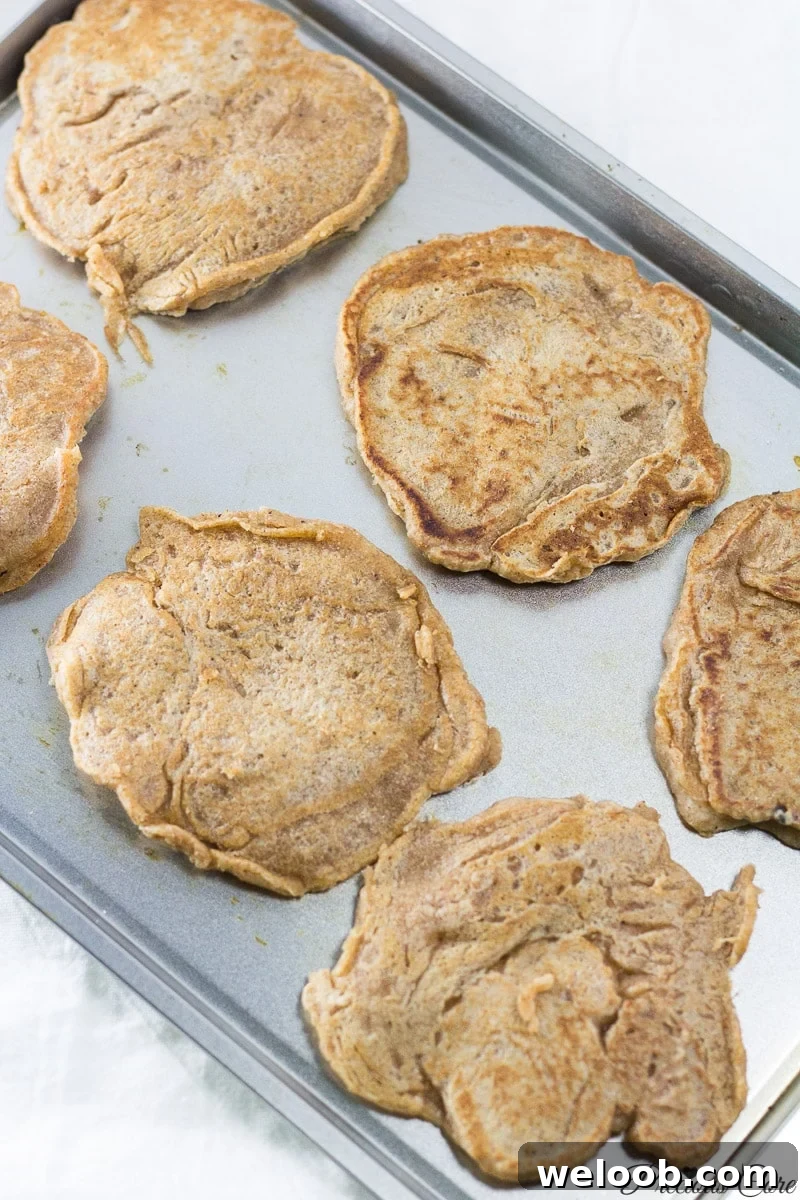 Eggless pancakes on a lined baking sheet.