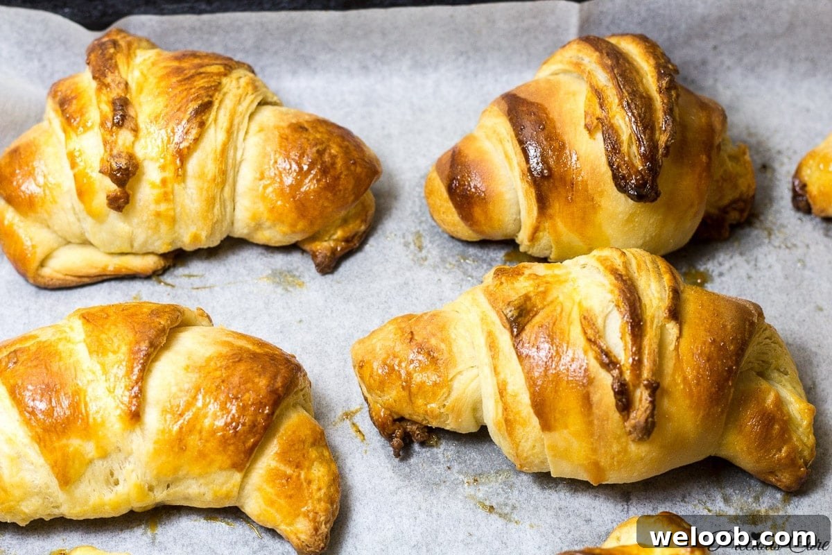 Homemade croissants on parchment paper.