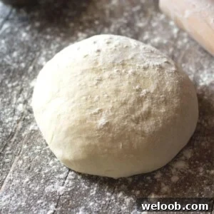 A ball of yeast free pizza dough on a wooden surface