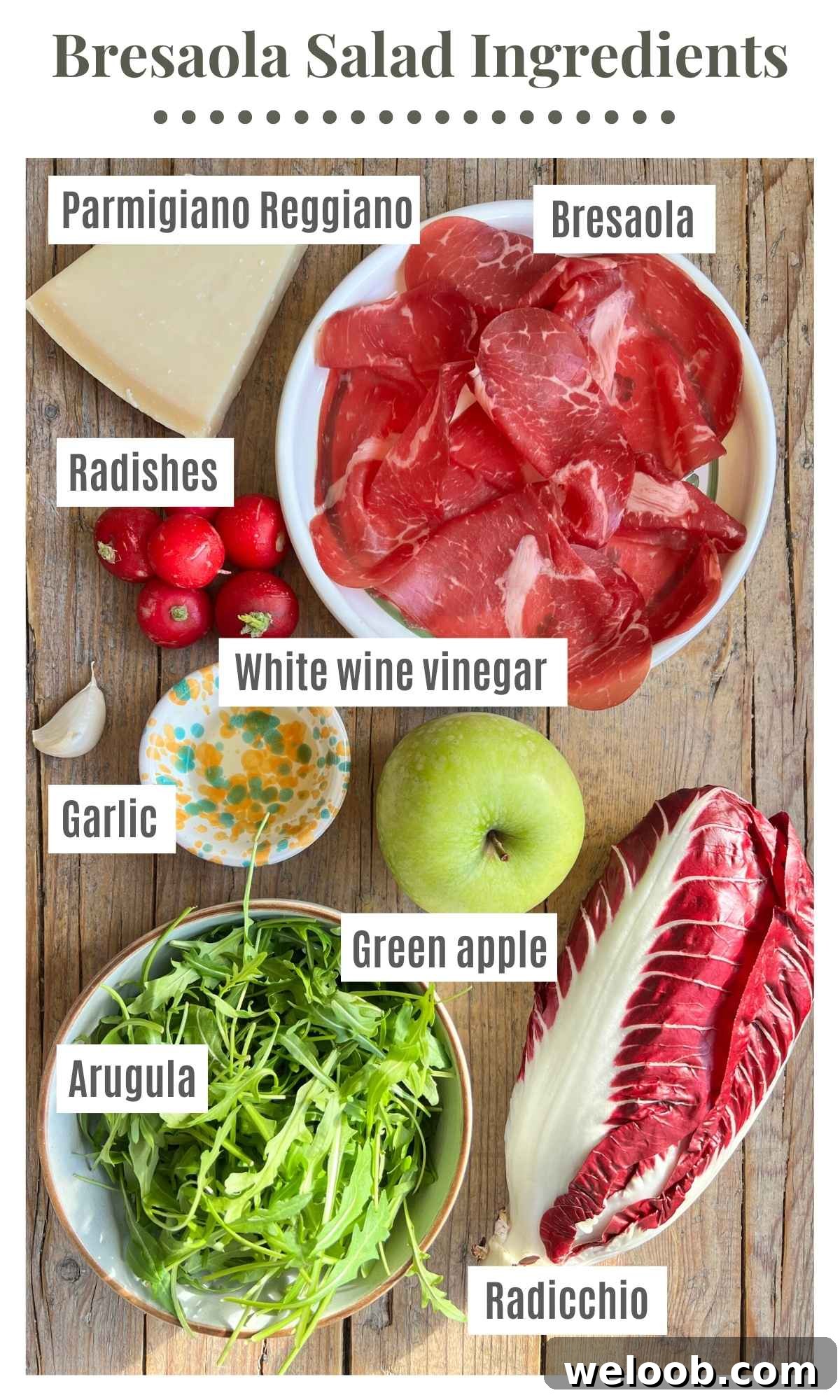 All the ingredients to make a bresaola salad on a wooden surface.