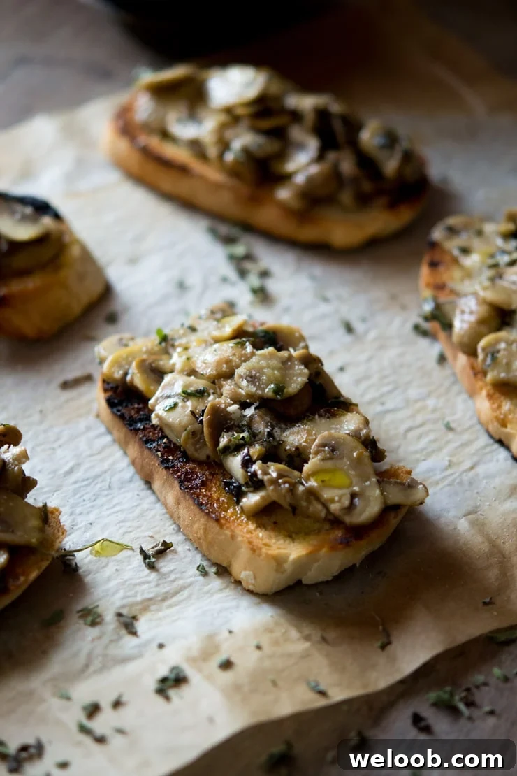 Mushroom toasts on a sheet of baking paper drizzled with olive oil