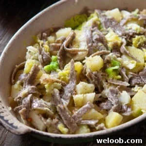 A close up of pizzoccheri pasta in a baking dish with potatoes and cabbage